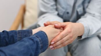 Entenda por que é importante ter um atendimento humanizado na cremação! Mãos entrelaçadas em sinal de apoio ilustram o atendimento humanizado na cremação.