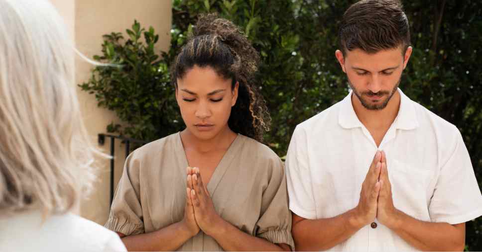 Casal de mãos juntas em oração para se despedir em velorio com cremação